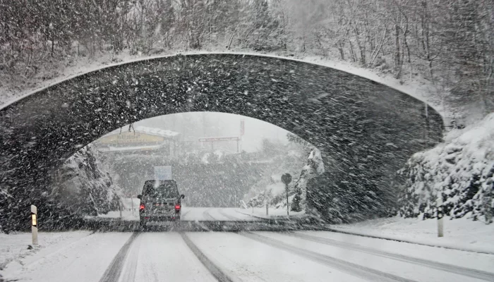 Van driving under bridge is heavy snow