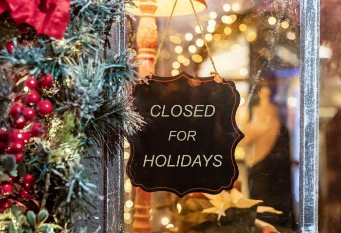'closed for the holidays' sign on the front window of a business, with a reef on the side.